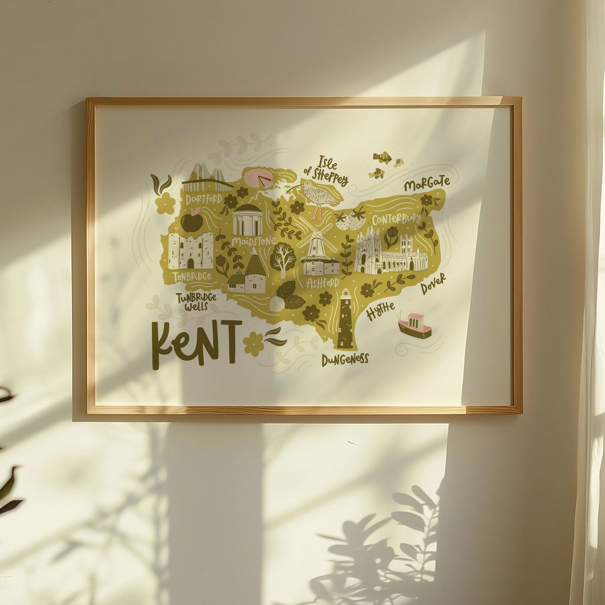 Lifestyle photo of an illustrated map of Kent, showing a framed print with a window shadow.