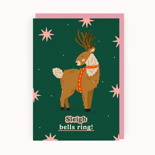 Christmas card with a reindeer illustration and caption 'Sleigh bells ring!' on a green background with pink stars.